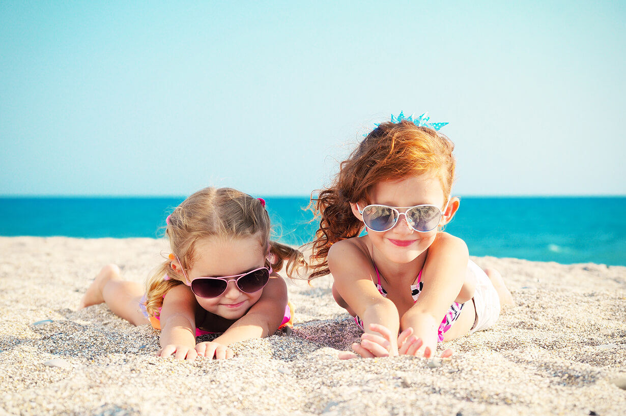 Two cute little lying in sand
